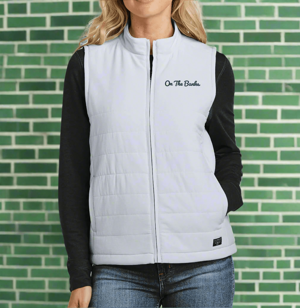 Michigan State women's vest on travismathew garment on female model in front of green brick wall