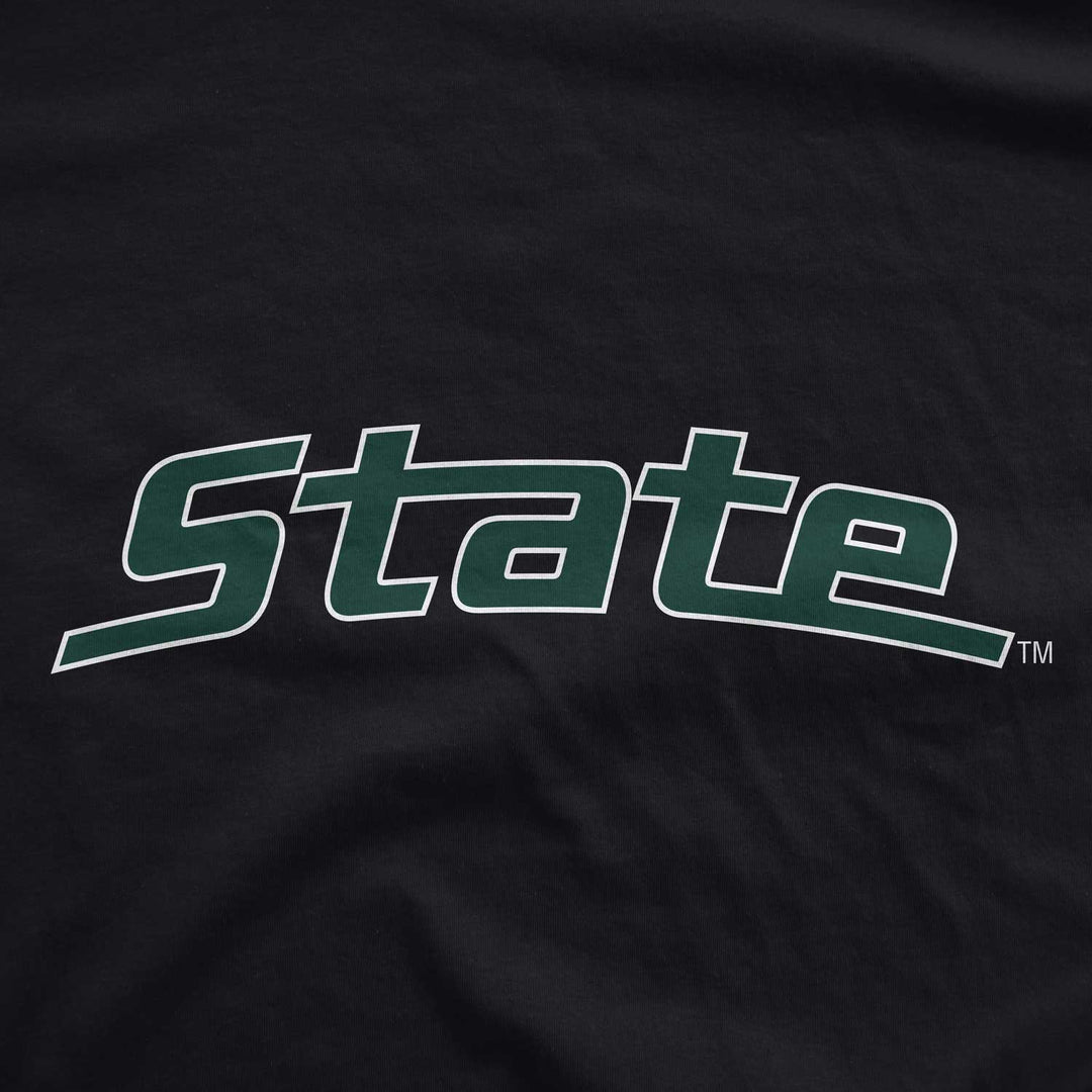 Close up of black Michigan State t-shirt with arched "State" logo printed in white and green ink.