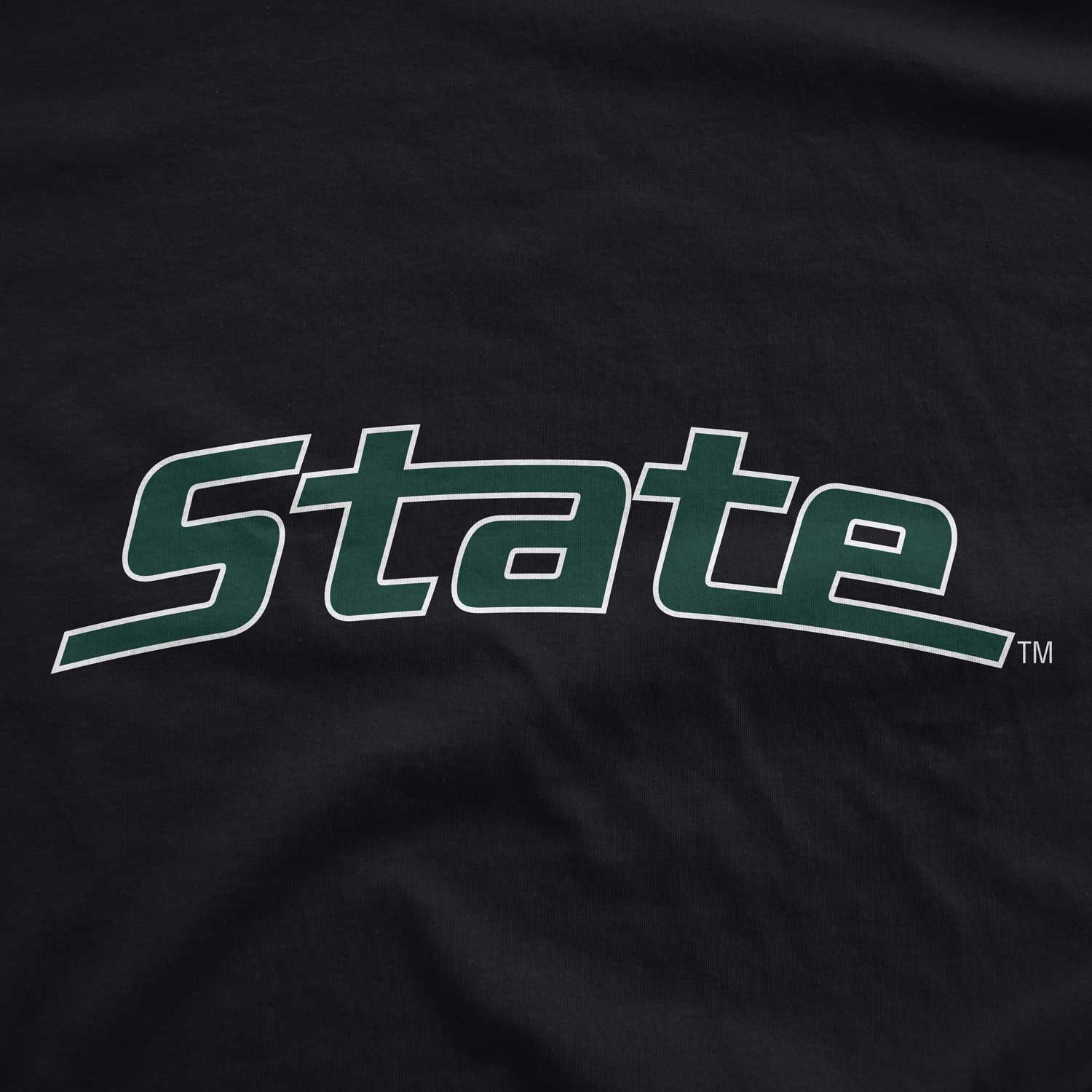 Close up of black Michigan State t-shirt with arched "State" logo printed in white and green ink.