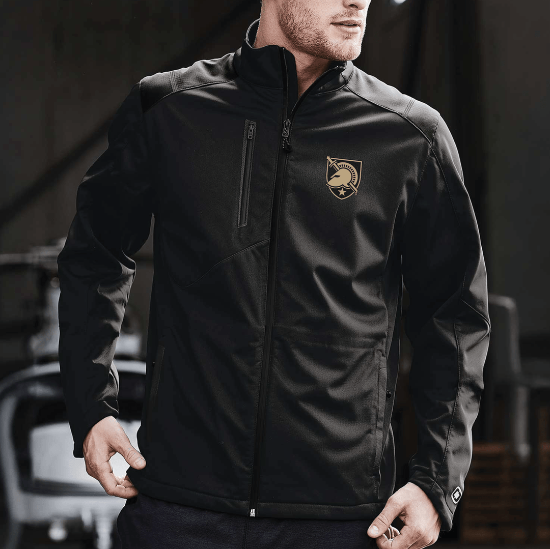 Male model wearing a black West Point jacket from OGIO featuring the Black Knights shield embroidered on the left chest.