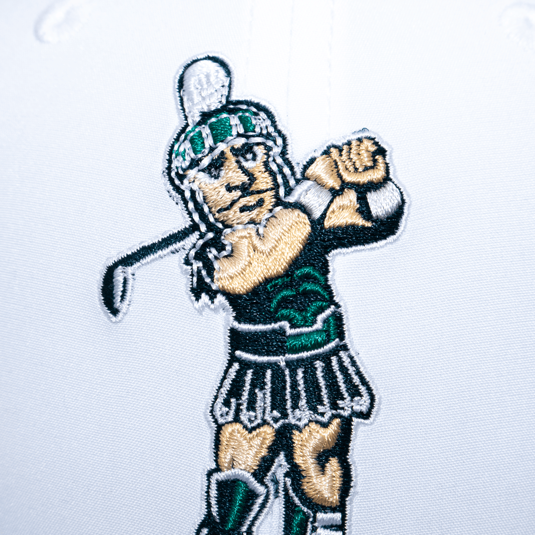 Close up view of the golfing Sparty logo embroidered on a white Michigan State hat.
