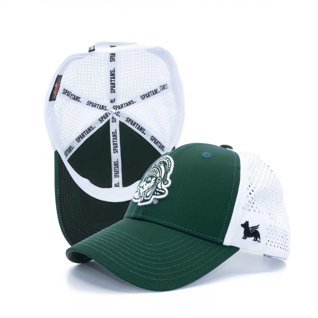 Shot of Michigan State hat to the side and secondary Michigan State hat standing vertical bottom side up.