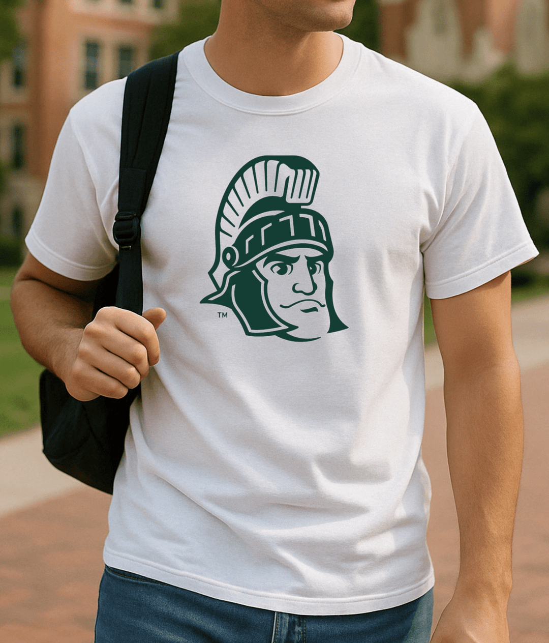 Michigan State White Shirt with Sparty Head Logo on male college student wearing a black backpack on campus