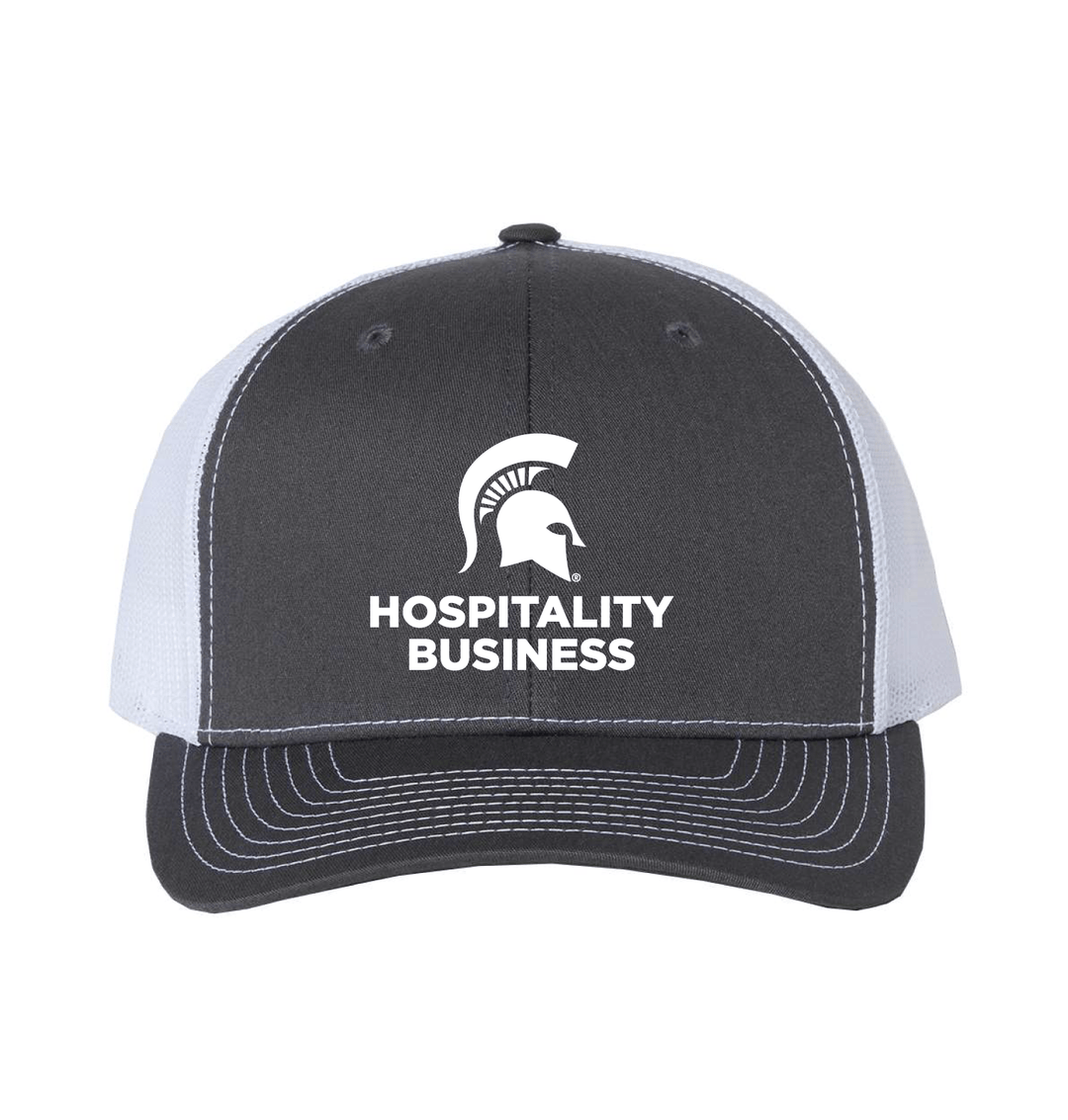 Charcoal and white Michigan State Hospitality Business trucker hat with embroidered Spartan helmet logo and Hospitality Business wordmark on the front panel.