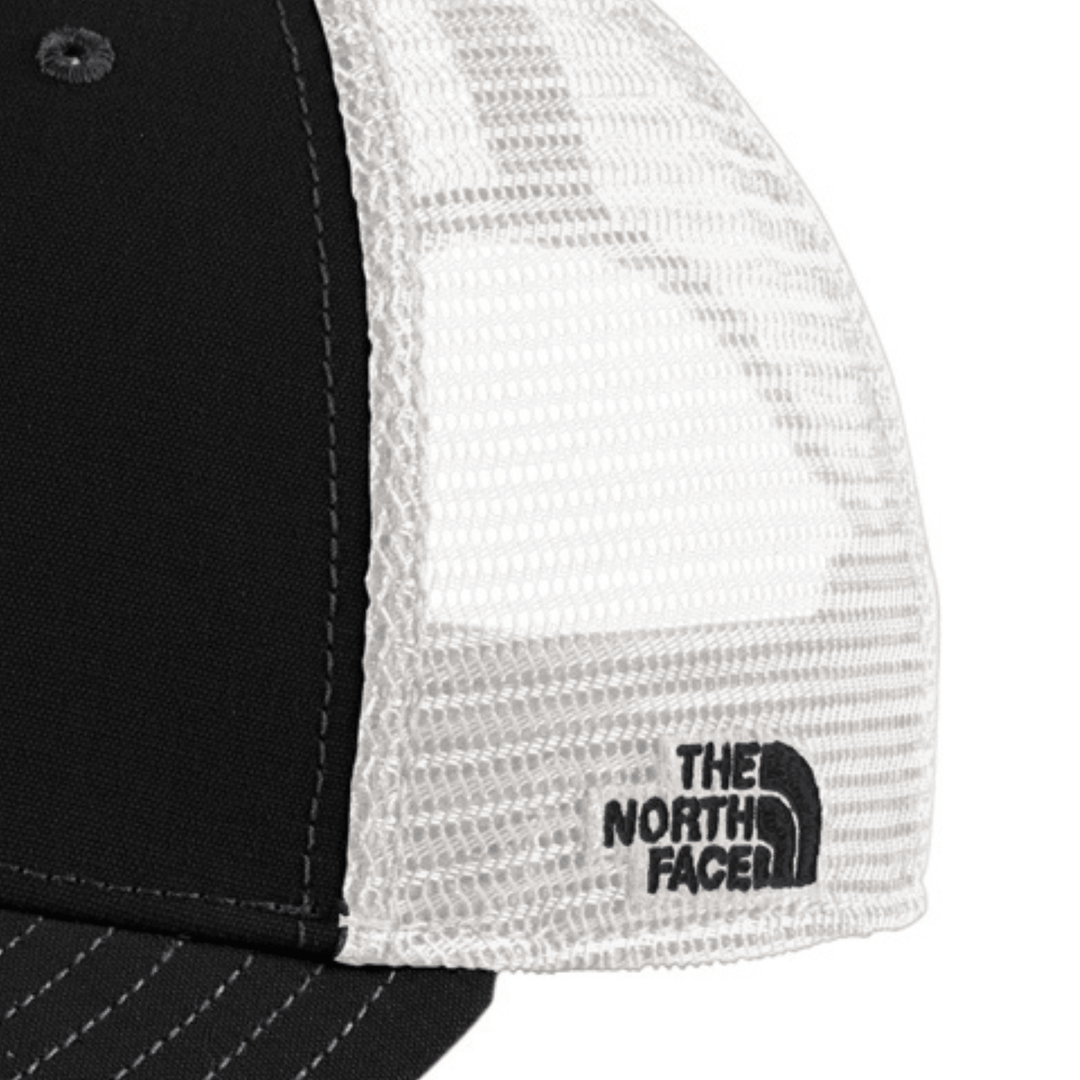 Close-up of the side mesh panel on the black The North Face Michigan State trucker hat showing the embroidered The North Face logo on the white mesh.