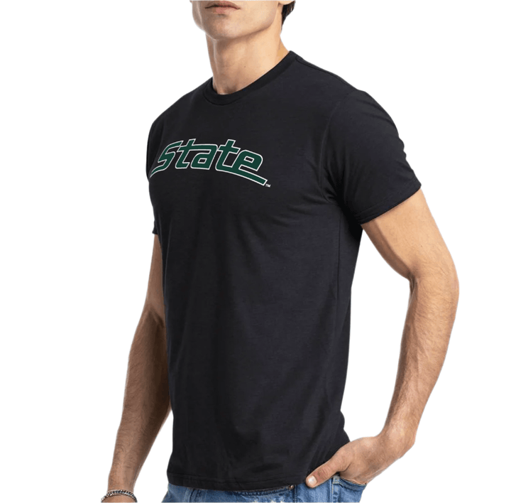 Male model wearing a black Michigan State t-shirt with the arched "State" logo printed across the chest in white and green ink. 
