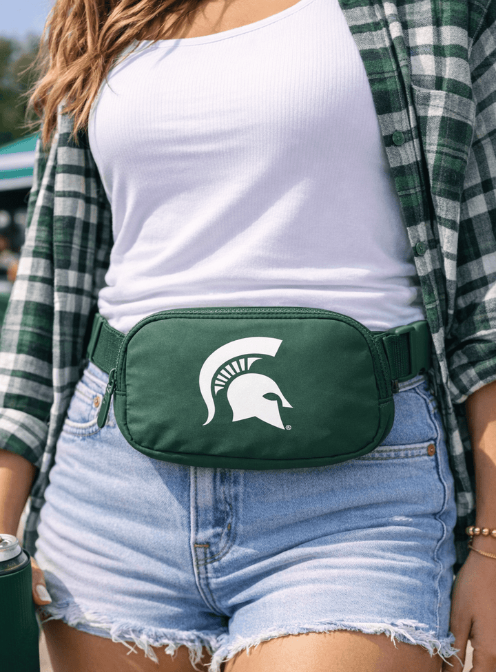 College student wearing MSU Spartan Helmet green belt bag at tailgate 