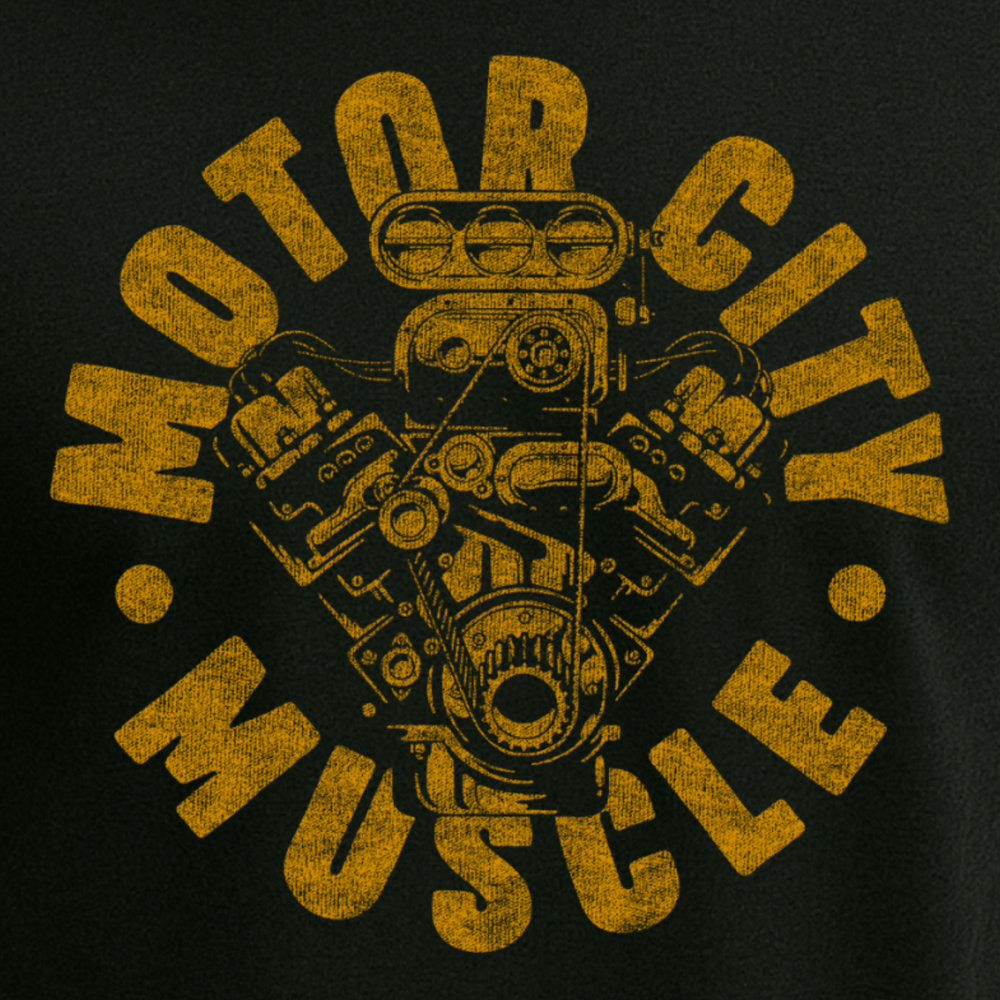 Close-up of Motor City Muscle t-shirt graphic featuring a detailed golden engine design on black fabric, celebrating Detroit’s automotive heritage and muscle car culture