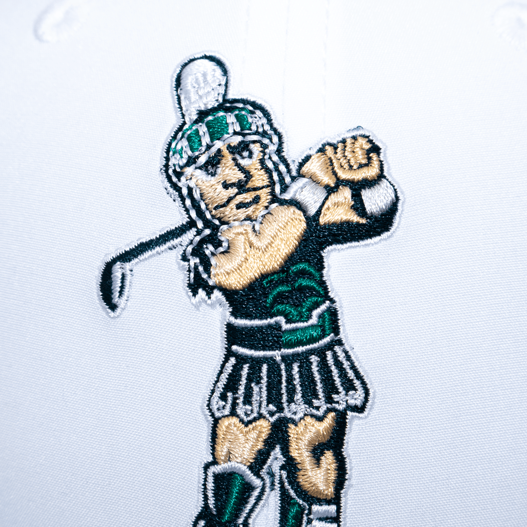 Close up view of the golfing Sparty logo embroidered on a white Michigan State hat. 