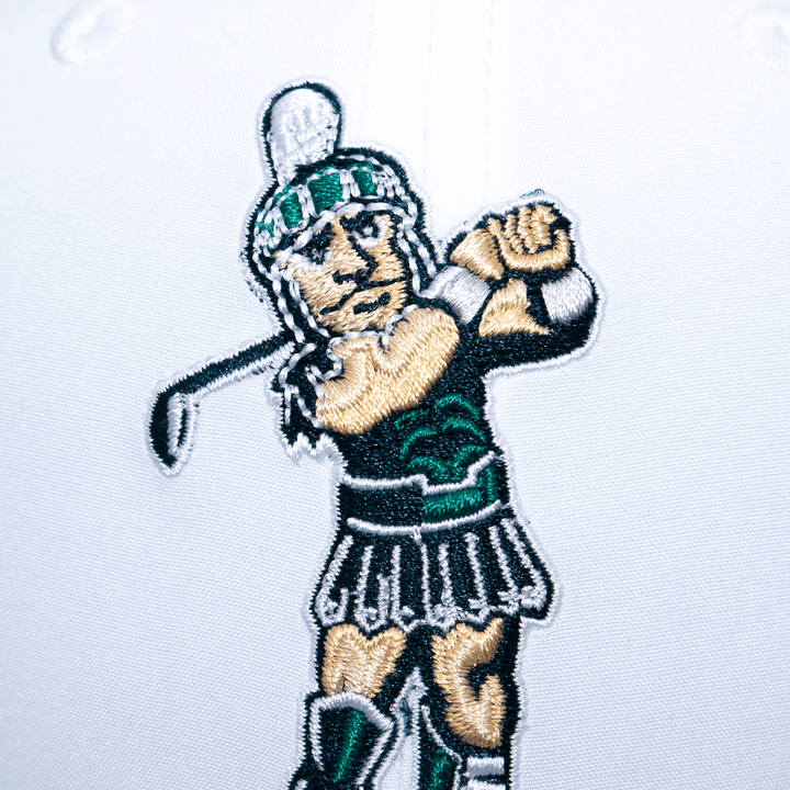 Close up view of the golfing Sparty logo embroidered on a white Michigan State hat. 