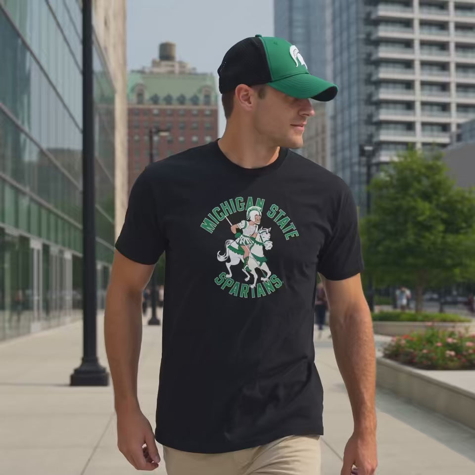 Man in Michigan State Sparty on horse black t-shirt and MSU Green Helmet Hat on Campus
