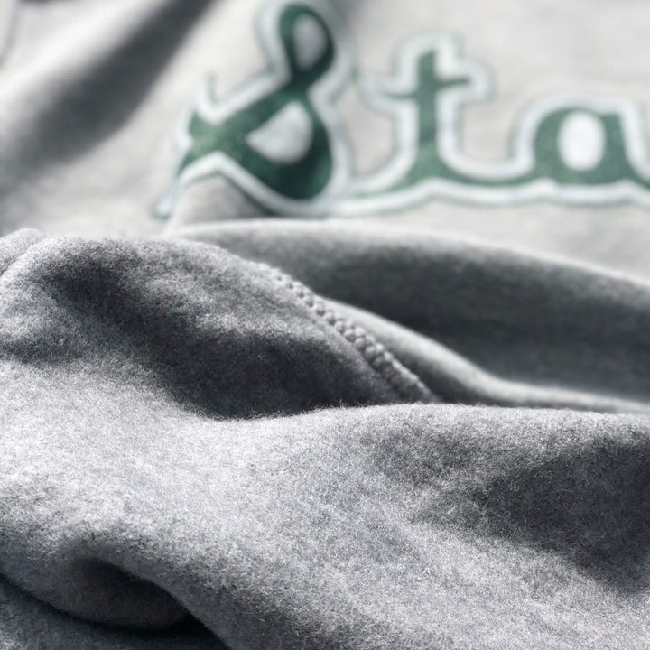 Close up of Michigan State Hooded sweatshirt with state script design